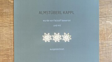 A certificate for the Almstüberl Kappl from the Falstaff Hut Guide 2022. It shows that the restaurant has been rated and awarded.