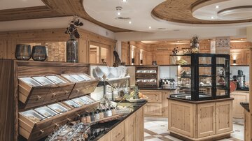 A stylish shop with wooden paneling and a selection of delicacies. The display case showcases various products and creates an inviting atmosphere.