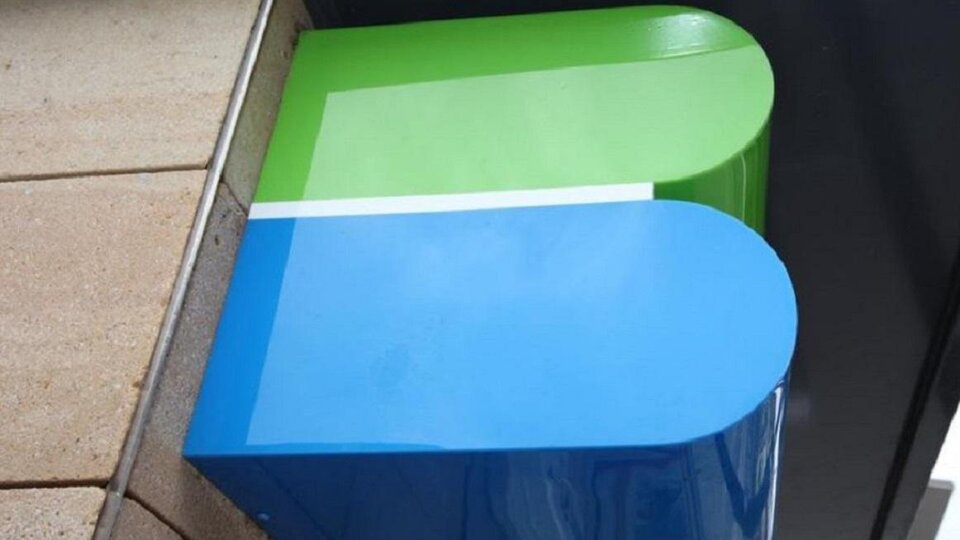 A modern, colorful logo in blue and green. It has rounded corners and is mounted on a wall.
