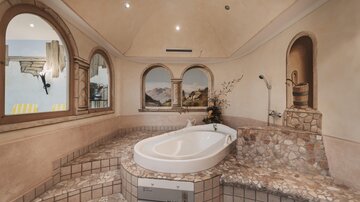 An elegant bathroom with a modern bathtub and decorated walls. The design creates a relaxing atmosphere.