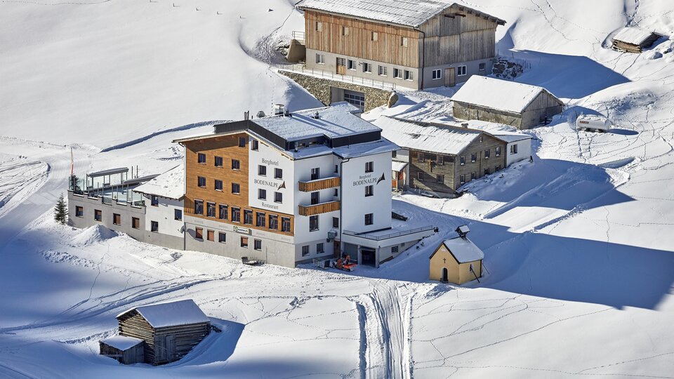 A beautiful, snow-covered mountain village with several houses. The surroundings are quiet and picturesque.