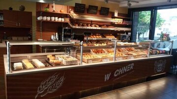 An attractive bakery with a variety of fresh baked goods and an inviting counter. Bright and modern decor with plenty of natural light.