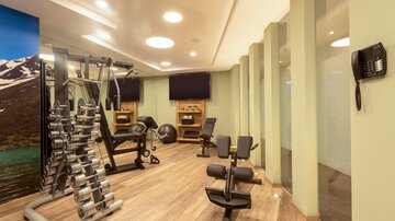 A modern gym with various equipment for training. There is a friendly atmosphere and plenty of space for working out.
