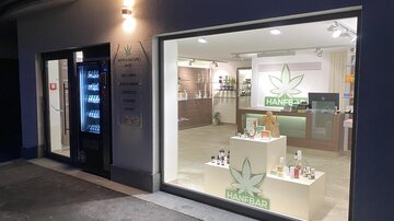 A modern shop with a clear display window. Inside, various cosmetic products and a reception desk are visible.
