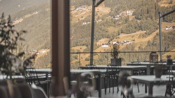 A stylish restaurant with a view of the mountains. The tables are elegantly set and the view is breathtaking.