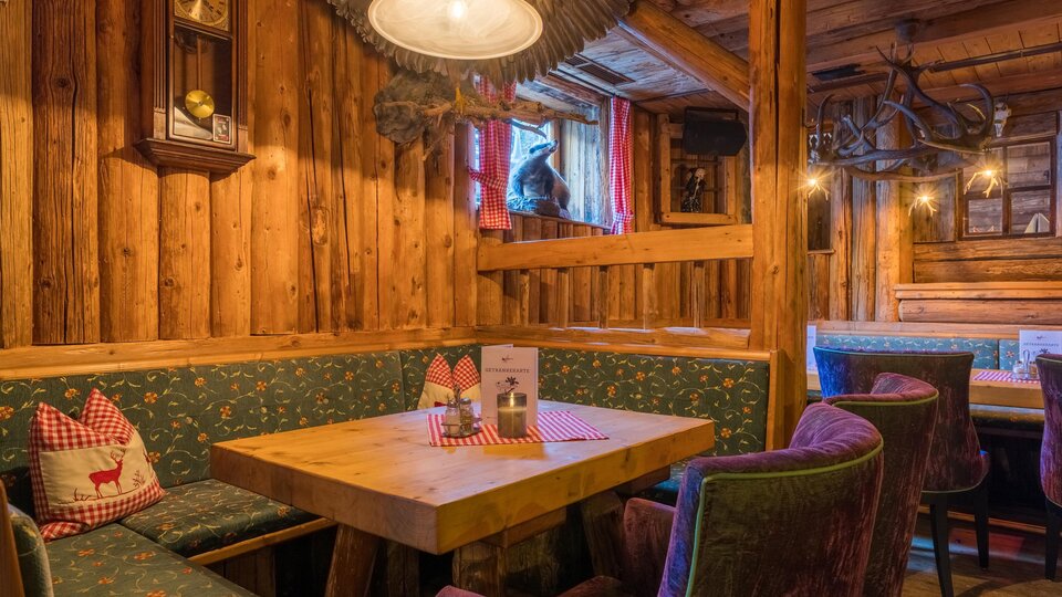 A cozy parlor with wood-paneled walls and comfortable seating. Menu cards are on the table and the atmosphere is inviting.
