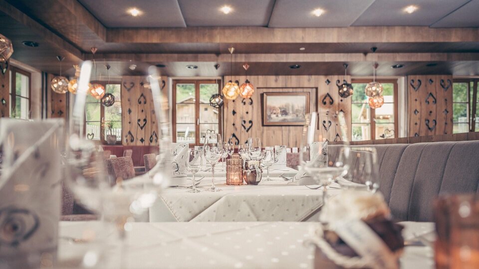 A cozy restaurant with elegantly set tables. Soft lighting and rustic elements create an inviting atmosphere.