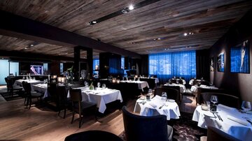 A stylish restaurant with elegant tables and dim lighting. The atmosphere is modern and inviting.