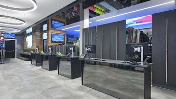 A modern store with multiple counters and screens. The decor is stylish and offers a variety of sports items.