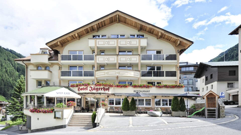 A charming hotel with alpine design and several balconies. Surrounded by mountains and a peaceful setting.
