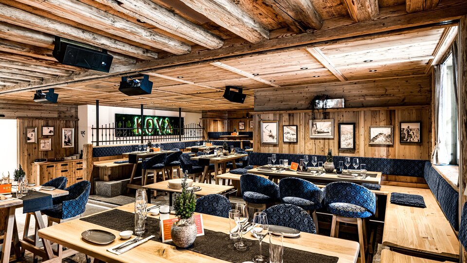A modern restaurant with wooden interior and cozy atmosphere. The tables are elegantly set and provide space for many guests.