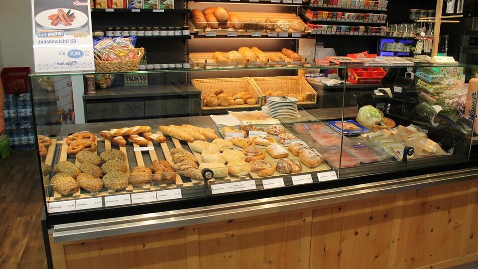 A bakery with a selection of pastries and rolls. In the background, various snacks and drinks can be seen.