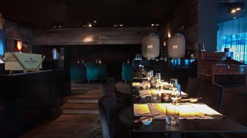 A stylish restaurant with dim lighting and elegant furniture. The tables are lovingly set and create a cozy atmosphere.