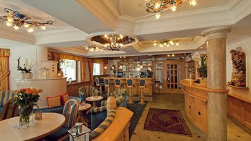 An elegant café with cozy seating and stylish lighting. The decor is warm and inviting, perfect for relaxation and socializing.