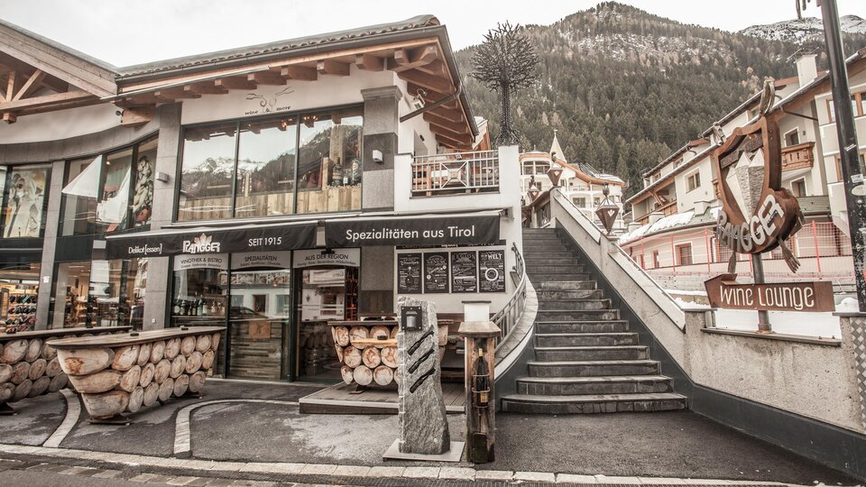 A cozy place with wooden furniture and an inviting restaurant. In the background, the mountains are visible, creating an alpine atmosphere.