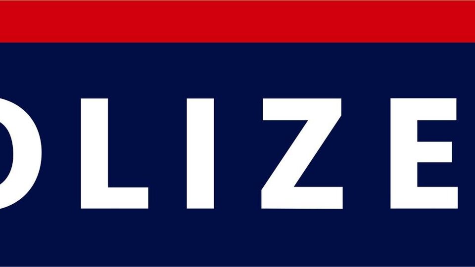 A sign of the police with the word "POLICE" in large, white letters. Below is an emblem depicted.