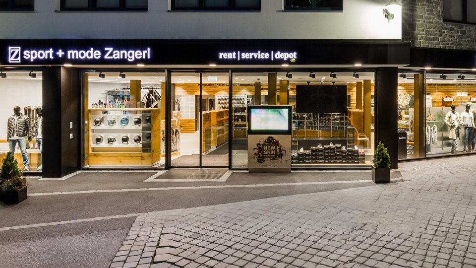 A sports store with large windows that showcases a variety of sports goods. The facade is modern and inviting, ideal for sports and fashion enthusiasts.