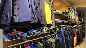 A clothing store with various jackets and shirts. The shelves are neatly decorated with sports and outdoor clothing.