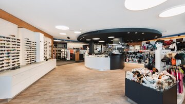 A modern store with a wide selection of sunglasses and accessories. The bright, inviting design creates a pleasant shopping atmosphere.