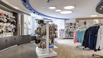 A modern retail space with various accessories, including hats and clothing. The walls are designed in a bright and friendly manner, creating an inviting atmosphere.