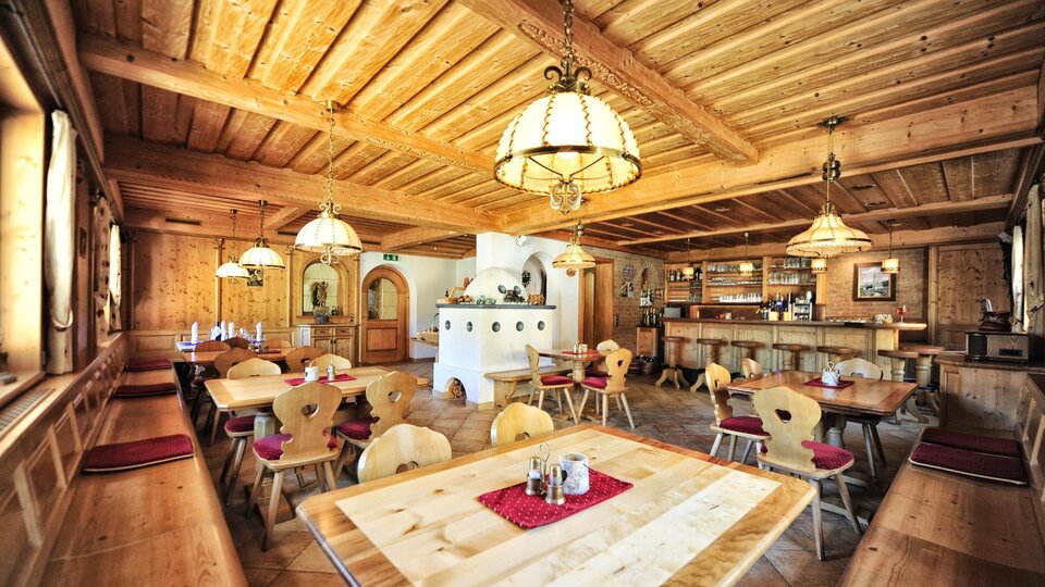 Ein gemütliches Restaurant mit Holzdekor und warmem Licht. Die Tische sind ordentlich gedeckt und bieten Platz für Gäste.