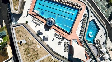 Ein schöner Swimmingpool mit Liegen und Sonnenschirmen. Im Hintergrund befindet sich ein entspannendes Spa.