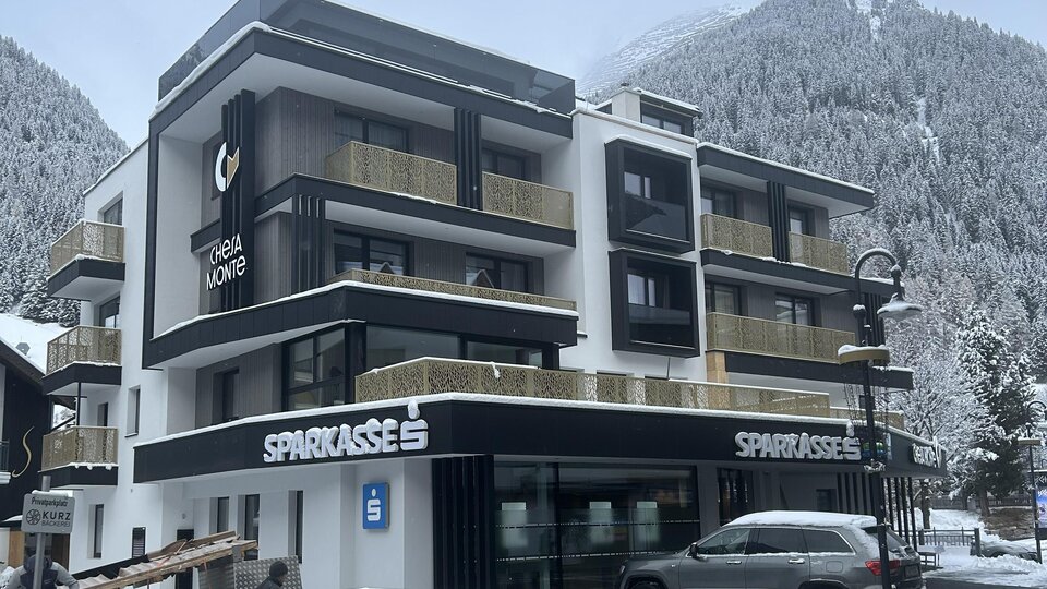 A modern building in a snow-covered landscape. The architecture is contemporary with large windows and a clear design.