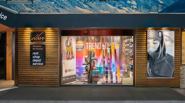 A sports store with a display window showcasing skis and equipment. Above are images of skiers and a large sign reading "TRENDHOUSE".