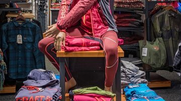 A display window with a mannequin showcasing sportswear by Craft. In the background, additional clothing items and accessories are arranged.
