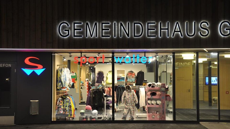 A store with sports clothing and accessories can be seen. The lighting creates an inviting atmosphere.