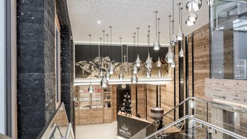 A modern reception hall with wood and stone elements. Hanging lamps provide stylish lighting.
