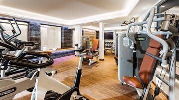 A modern gym with various training equipment. The room is bright and inviting, ideal for sports activities.