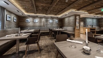 A modern restaurant with wooden ceilings and stylish tables. The decor is cozy and inviting.