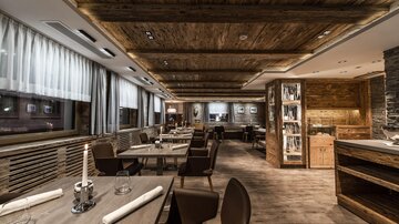 A modern restaurant with wooden paneling and stylish furniture. The atmosphere is cozy and inviting.