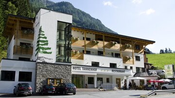 A cozy hotel with a modern and traditional design. There is a terrace with tables and chairs as well as a beautiful view of the surrounding mountains.