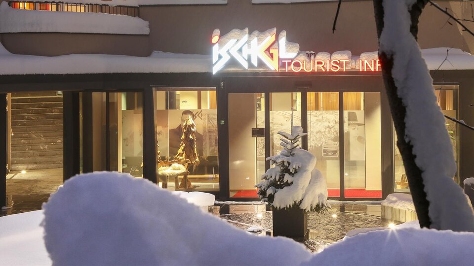 A modern building with the sign "Tourist Info" in a snowy landscape. The entrance is inviting and shows a wintry atmosphere.