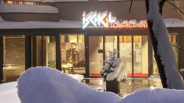 A modern building with the sign "Tourist Info" in a snowy landscape. The entrance is inviting and shows a wintry atmosphere.