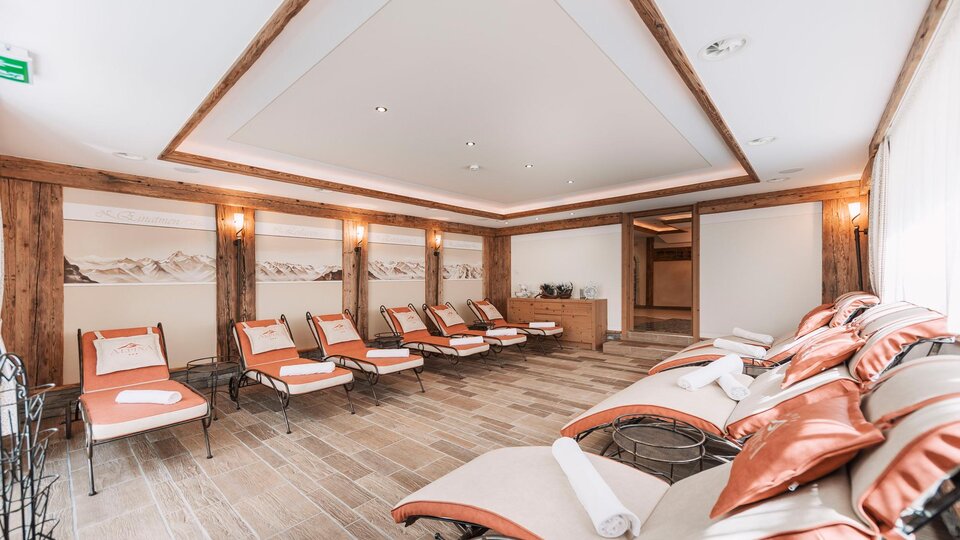 A relaxing wellness area with comfortable loungers and warm colors. The room is bright and modernly designed, ideal for peace and relaxation.