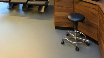 A modern hair salon with several chairs and wooden shelves. The decor is minimalist and inviting.