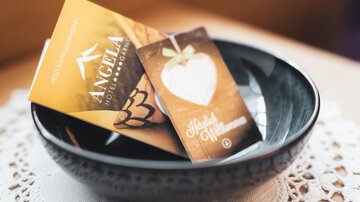 A black bowl contains two cards. One card is for a hotel and the other is a welcome card.