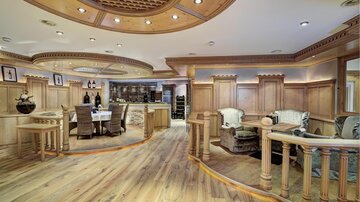 Ein stilvolles Interieur mit Holzverkleidung und eleganten Möbeln. Der Raum ist hell und einladend, ideal für geselliges Beisammensein.