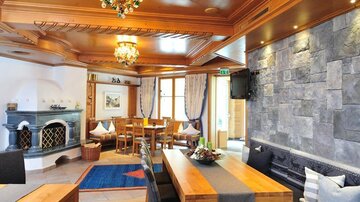 A cozy living space with wood decor and a stylish stone wall. The room has a large table and a pleasant atmosphere.