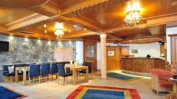 An inviting reception area with wood-paneled walls and cozy seating. The atmosphere is warm and modern, ideal for guests.