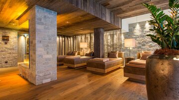 Ein stilvolles Spa mit Holz- und Steinelementen. Entspannte Liegen laden zur Erholung ein.