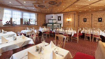 A cozy restaurant with paneled wooden walls and elegant tablecloths. The interior decor exudes an inviting atmosphere.